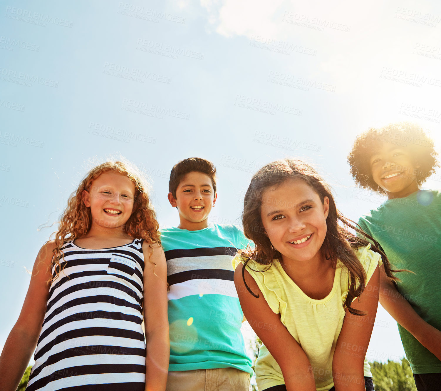 Buy stock photo Happy children, portrait and nature with sunshine for bonding, holiday or outdoor weekend below. Low angle, group or kids with smile or lens flare for summer vacation, freedom or playful day in park