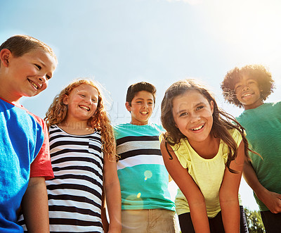 Buy stock photo Portrait of a group of diverse and happy kids hanging out together on a bright day outside