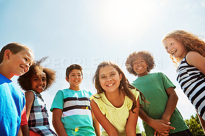 Buy stock photo Portrait of a group of diverse and happy kids hanging out together on a bright day outside