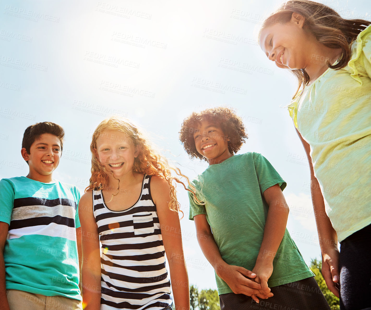 Buy stock photo Portrait of a group of diverse and happy kids hanging out together on a bright day outside