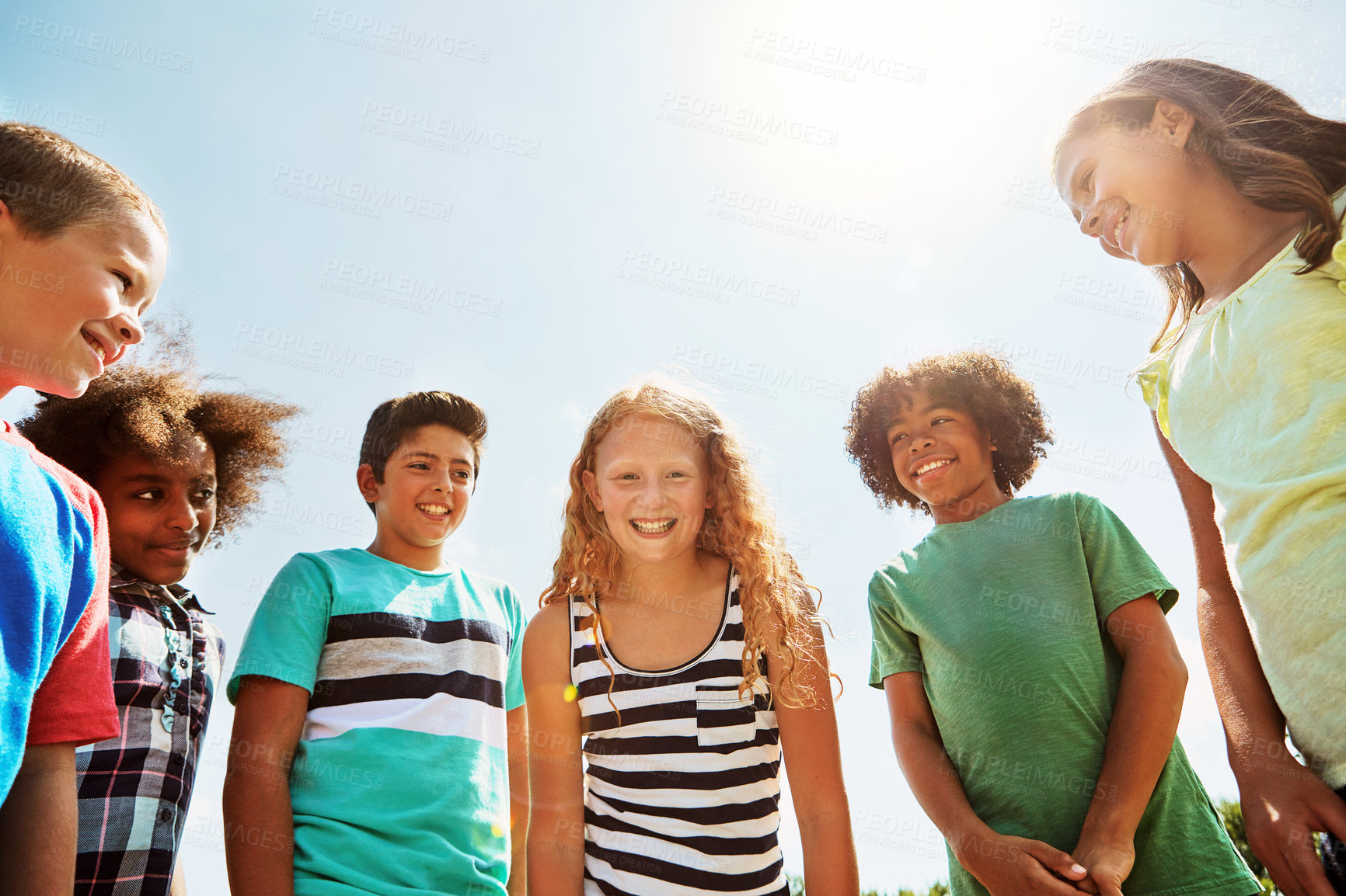 Buy stock photo Portrait of a group of diverse and happy kids hanging out together on a bright day outside