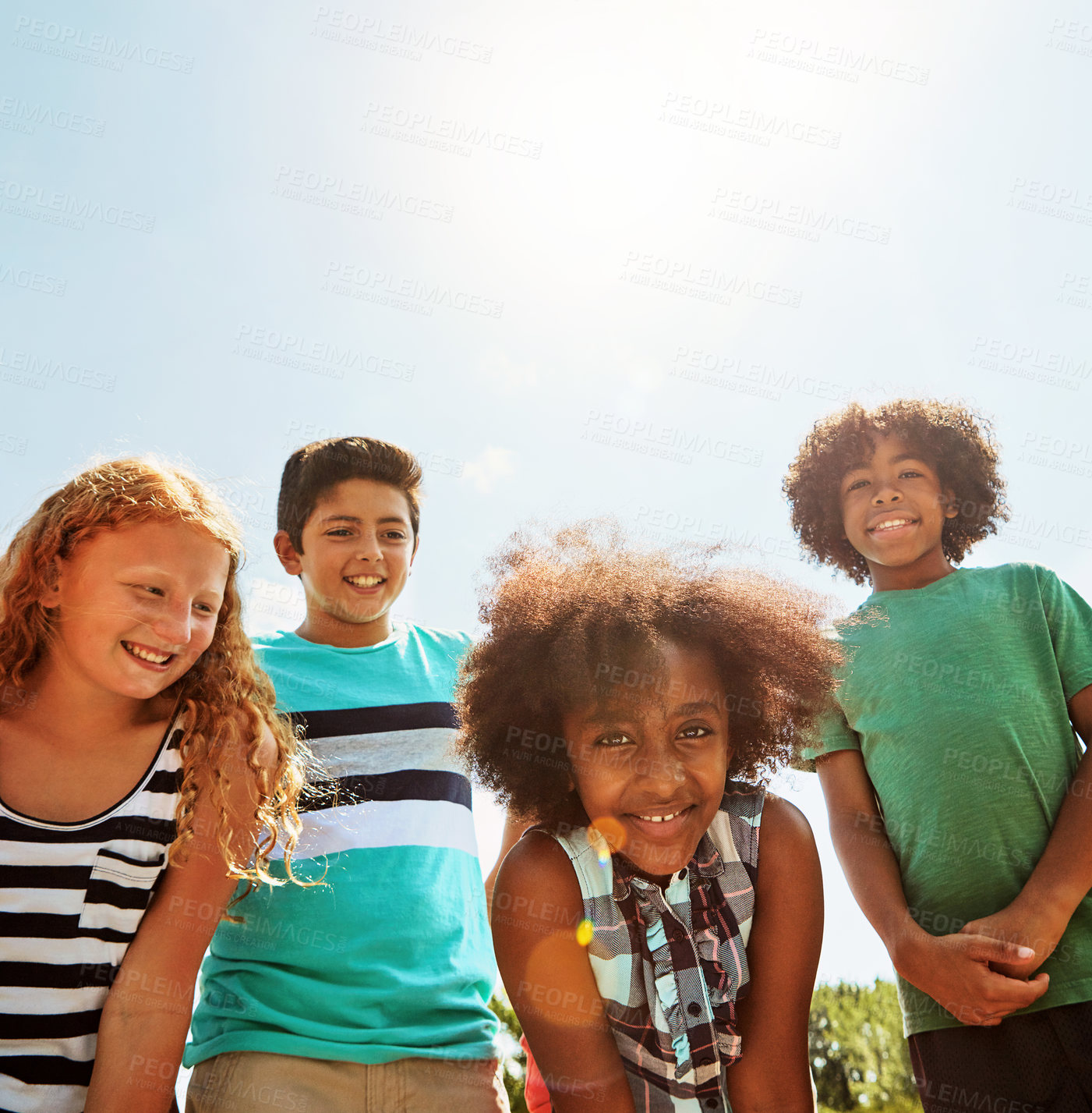 Buy stock photo Portrait of a group of diverse and happy kids hanging out together on a bright day outside