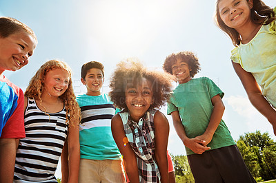 Buy stock photo Portrait of a group of diverse and happy kids hanging out together on a bright day outside