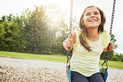 Buy stock photo Happy, nature and girl on swing in park for fun, adventure and play time on holiday or weekend trip. Smile, cute and kid or child on equipment on playground in outdoor field on vacation in Canada.