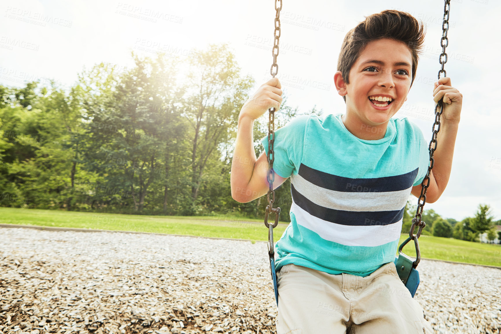 Buy stock photo Happy, nature and boy on swing in park for fun, adventure and play time on holiday or weekend trip. Smile, cute and child or kid on equipment on playground in outdoor field on vacation in Canada.