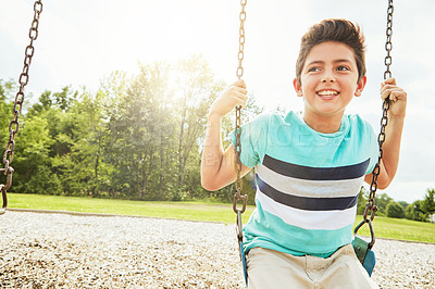 Buy stock photo Happy, nature and boy child on swing in park for fun, adventure and play time on holiday or weekend trip. Smile, cute and kid excited on playground in outdoor field on vacation in Canada with joy