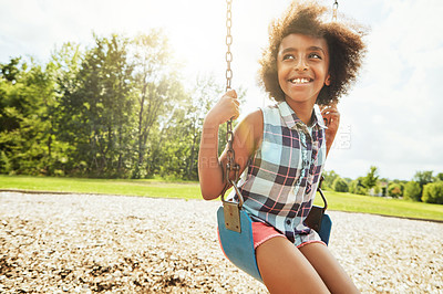 Buy stock photo Cropped shot of a young girl playing on a swing at the park