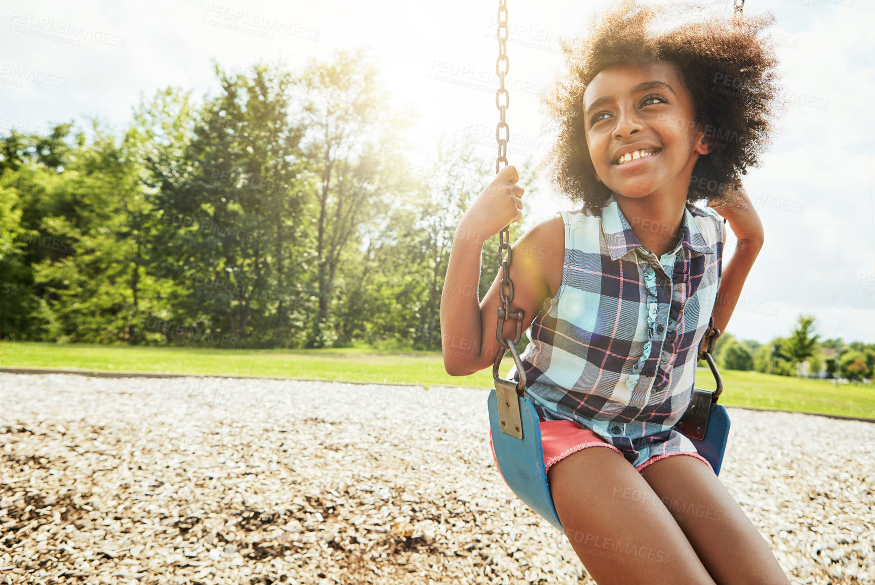 Buy stock photo Cropped shot of a young girl playing on a swing at the park