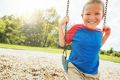 Buy stock photo Small boy, portrait and smile with swing, park and nature for outdoor fun and play with fresh air. Child, tree and playground with summer, freedom and school holiday or break outside with happiness