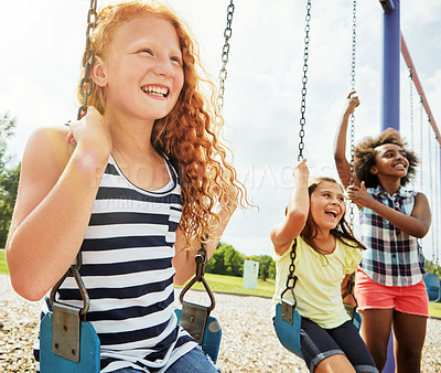 Buy stock photo Cropped shot of young girls playing on the swings at the park