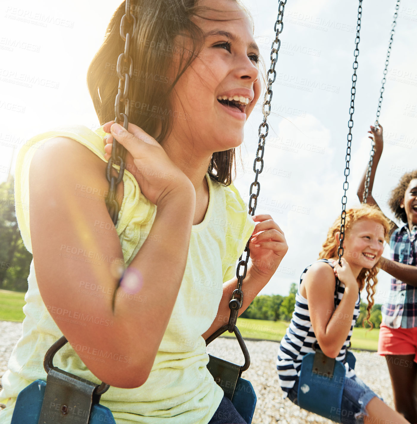 Buy stock photo Cropped shot of young girls playing on the swings at the park