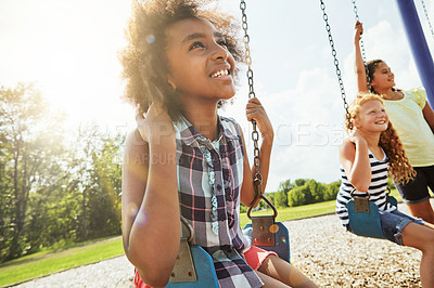 Buy stock photo Cropped shot of young girls playing on the swings at the park