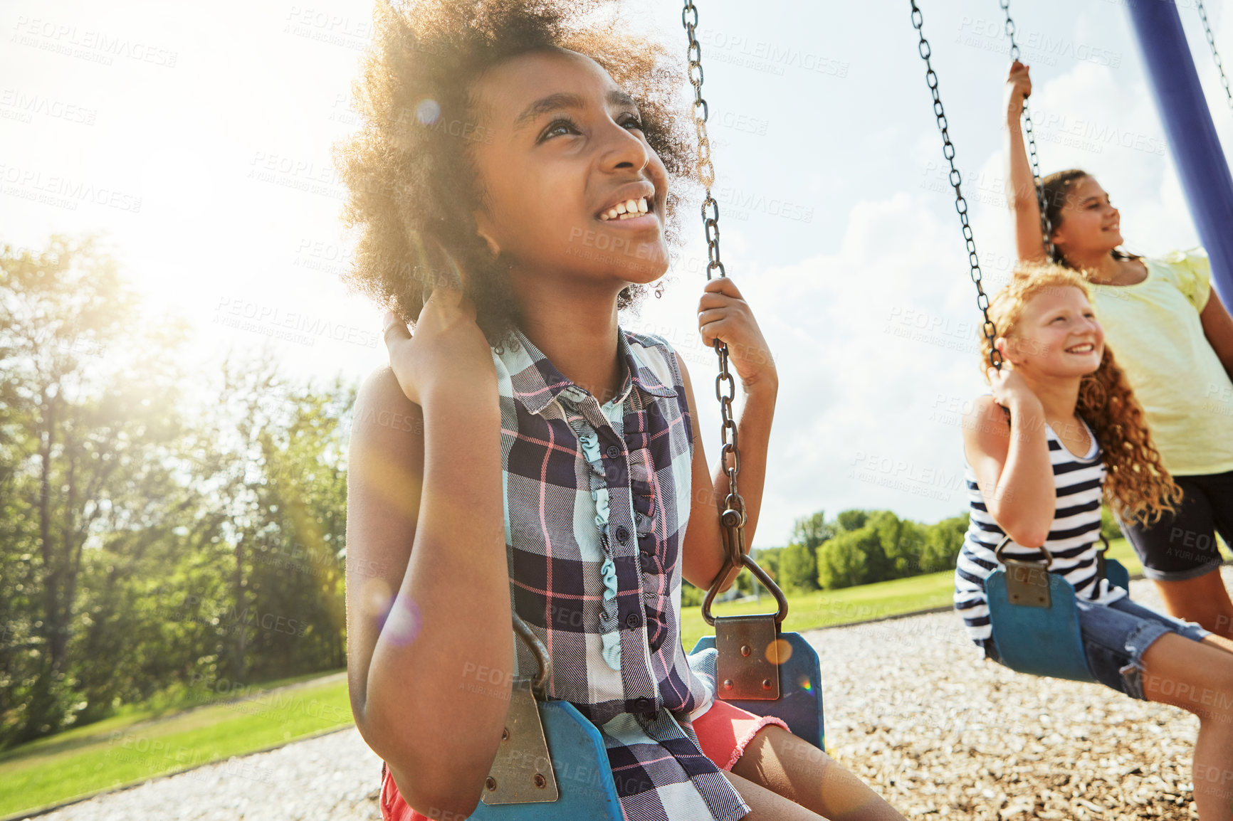 Buy stock photo Cropped shot of young girls playing on the swings at the park