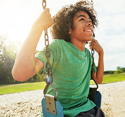 Buy stock photo Cropped shot of a young boy playing on a swing at the park