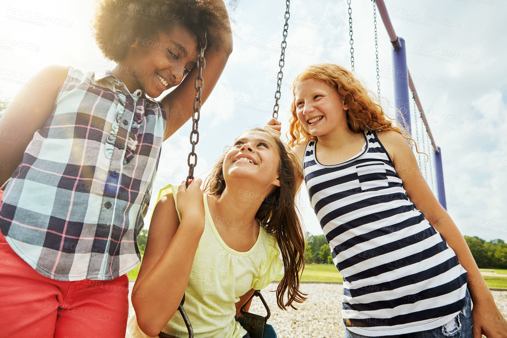 Buy stock photo Cropped shot of young girls playing on the swings at the park