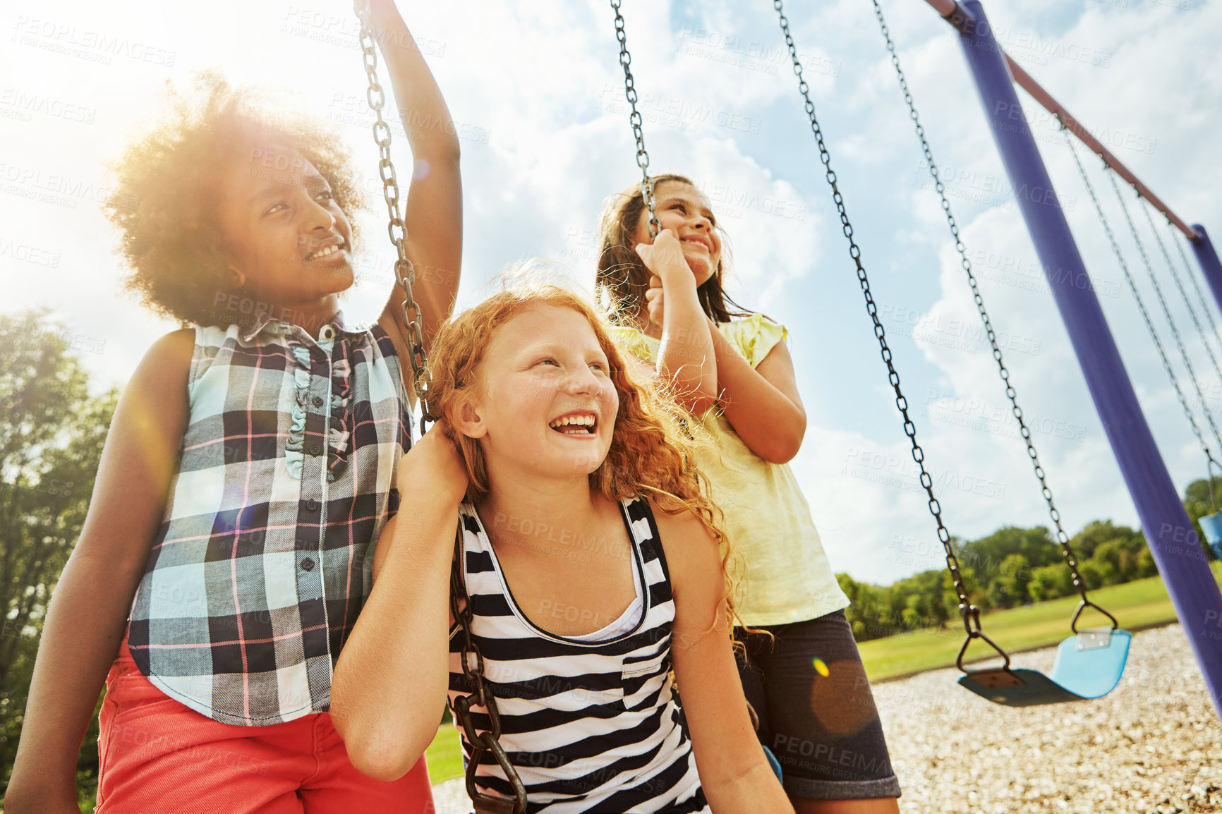 Buy stock photo Cropped shot of young girls playing on the swings at the park