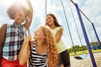 Buy stock photo Cropped shot of young girls playing on the swings at the park