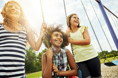 Buy stock photo Cropped shot of young girls playing on the swings at the park