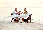 Middle aged couple enjoying romantic dinner at the beach