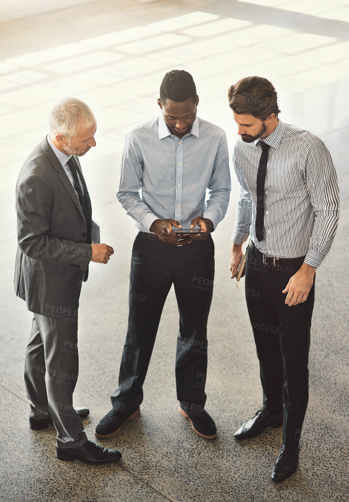 Buy stock photo High angle shot of businesspeople standing in a office lobby 