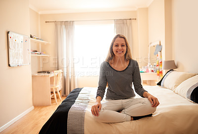 Buy stock photo Portrait of an attractive young woman sitting crossed-legged on her bed