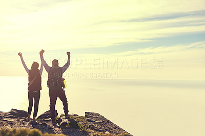Buy stock photo Rearview shot of a young couple admiring the view from the top of a mountain