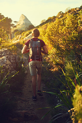 Buy stock photo Rearview shot of a young man exploring the outdoors alone on a hiking trail