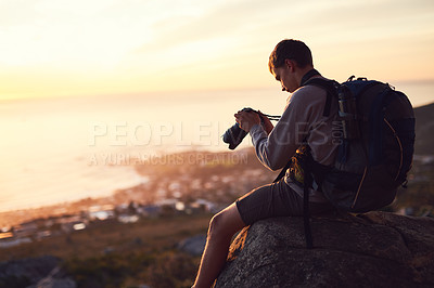 Buy stock photo Shot of a young photographer taking a picture from the top of a mountain