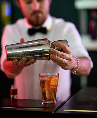 Buy stock photo Cropped shot of a barman mixing drinks in a nightclub