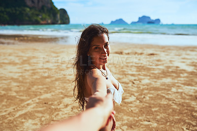 Buy stock photo Shot of a young woman leading someone's into the water