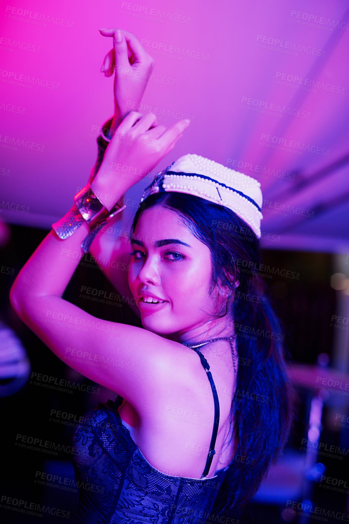 Buy stock photo Shot of a bar girl dancing in a neon lit Thai nightclub
