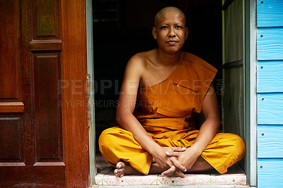 Buy stock photo Portrait of a buddhist monk sitting in the doorway of his home