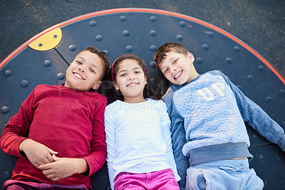 Buy stock photo Portrait of three young siblings playing together at the park