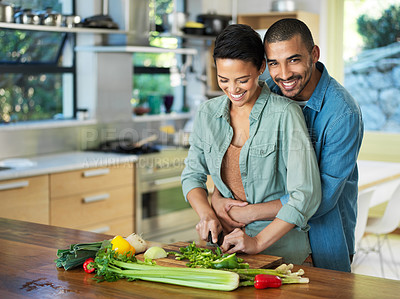 Buy stock photo Hugging, vegetables and couple cooking in kitchen for love, healthy food and bonding together with date. Smile, happy man and woman with knife for cutting, nutrition meal or preparation in home