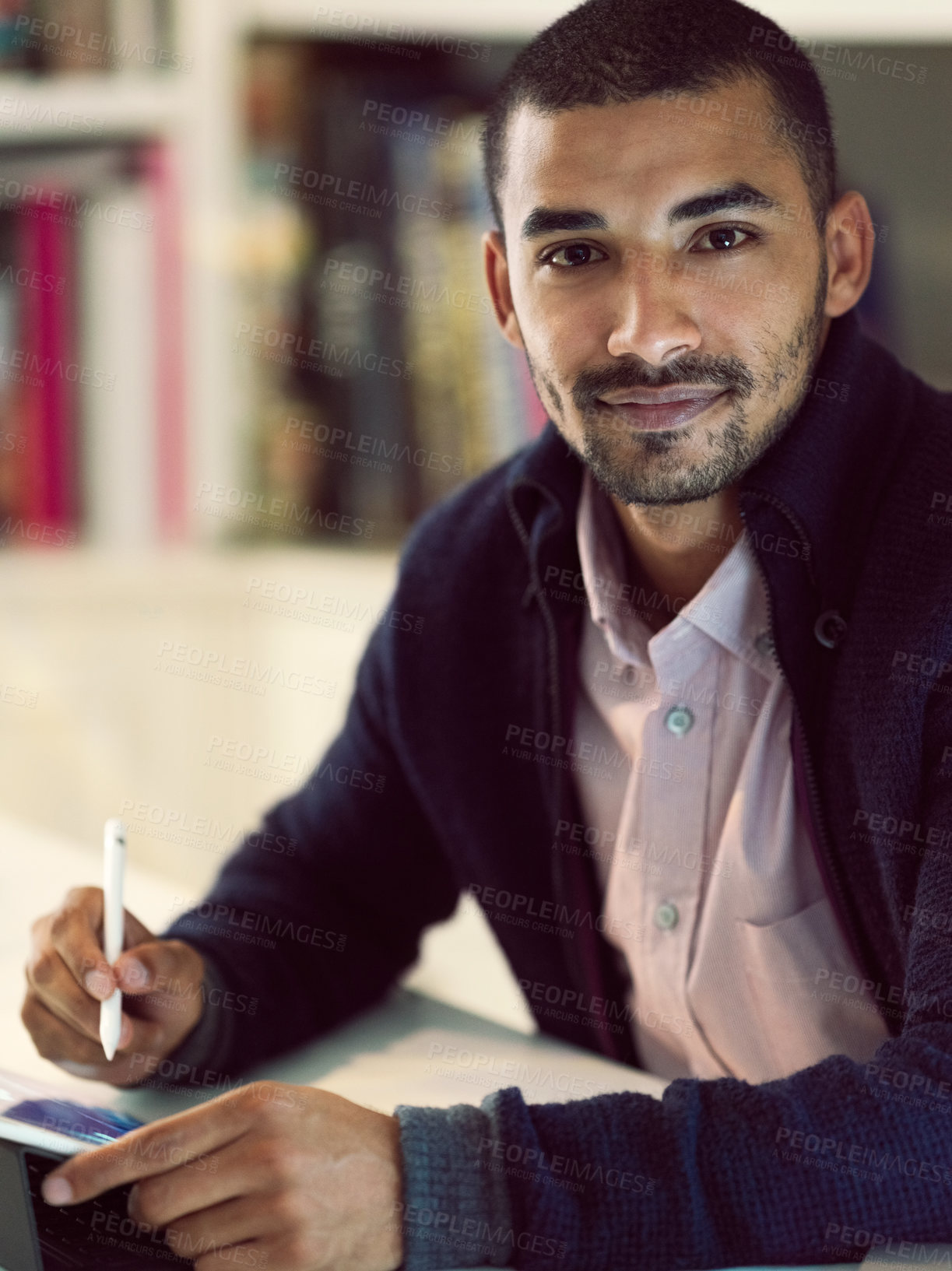 Buy stock photo Portrait of a focused young man working on a digital tablet in his home office in the early evening