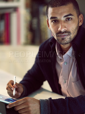 Buy stock photo Portrait of a focused young man working on a digital tablet in his home office in the early evening