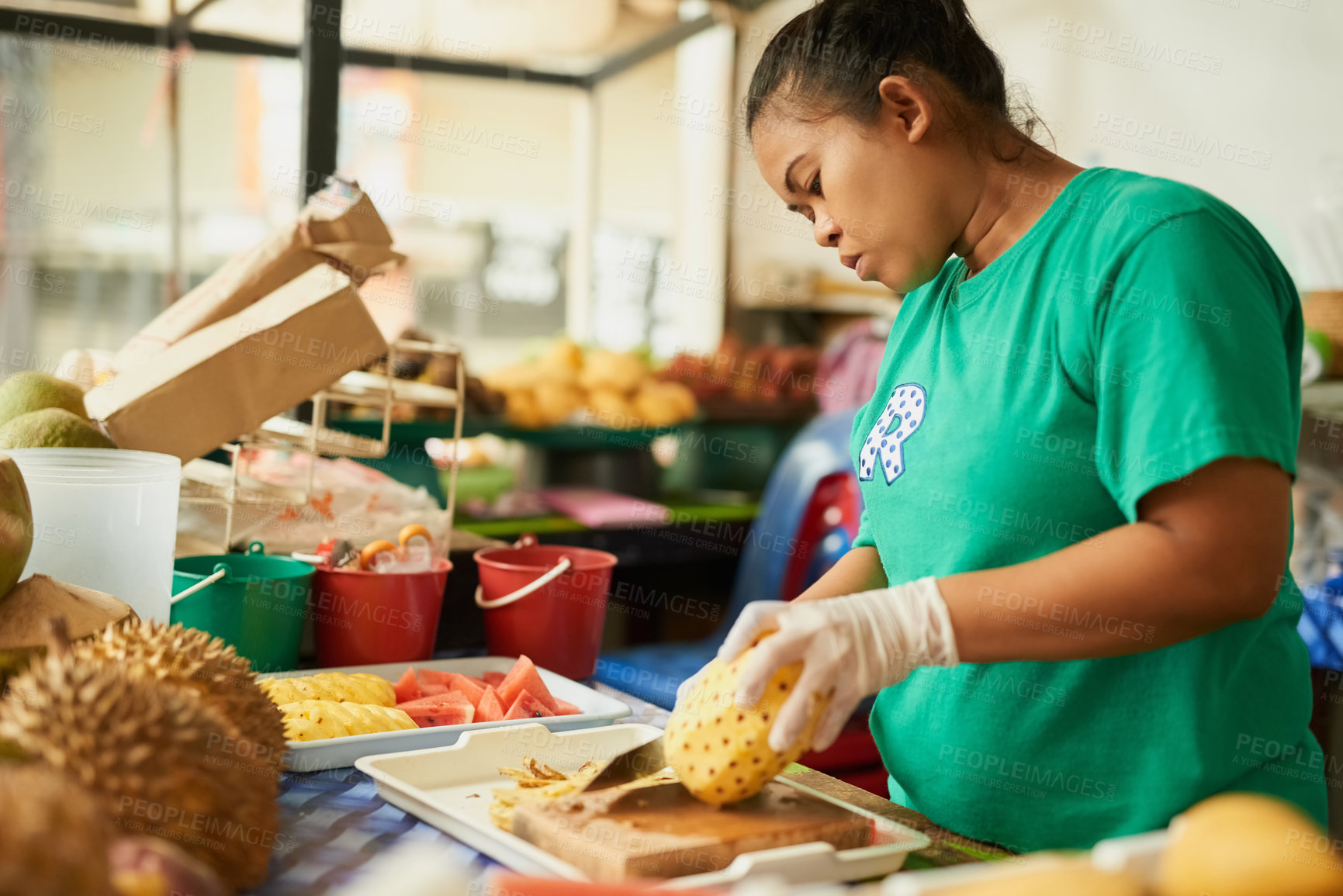 Buy stock photo Shot of a woman slicing fruit in a Thai food market