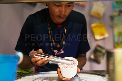 Buy stock photo Shot of a food vendor preparing a sweet treat at a market stall