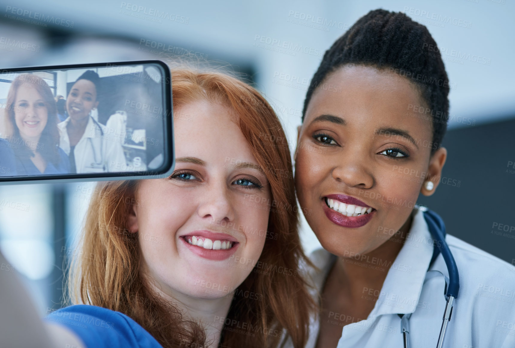 Buy stock photo Shot of two young doctors taking a selfie together