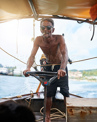 Buy stock photo Shot of a Thai man operating his tourist boat