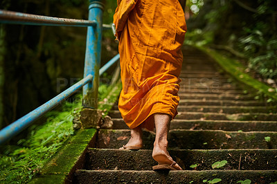 Buy stock photo Rearview shot of a buddhist monk climbing a flight of stone steps