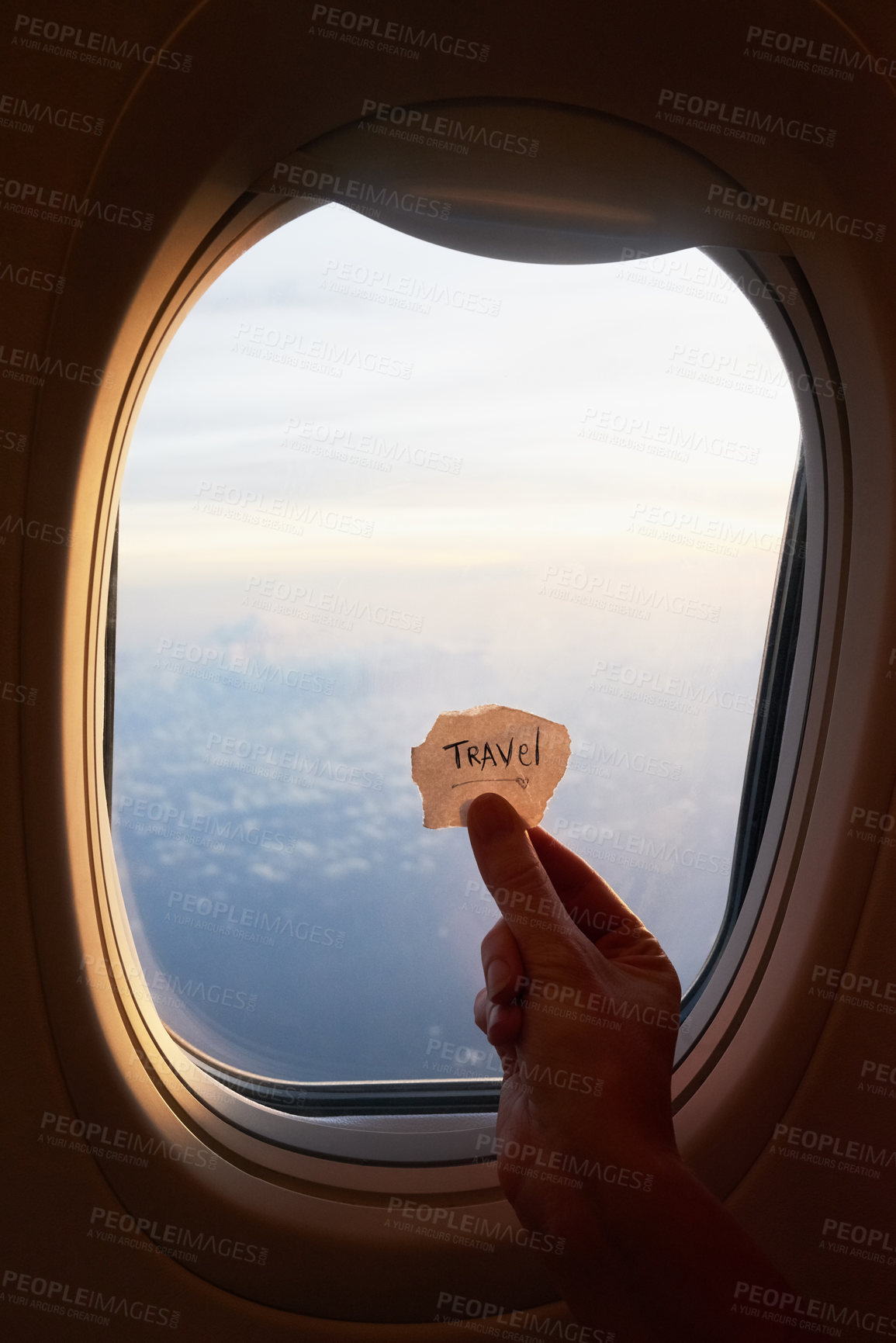 Buy stock photo Shot of an unrecognizable person's hand holding up a note against the window of a plane