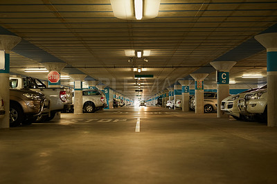 Buy stock photo Shot of an underground parking garage full of cars