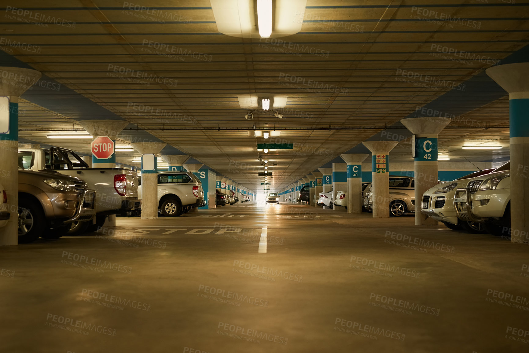 Buy stock photo Shot of an underground parking garage full of cars