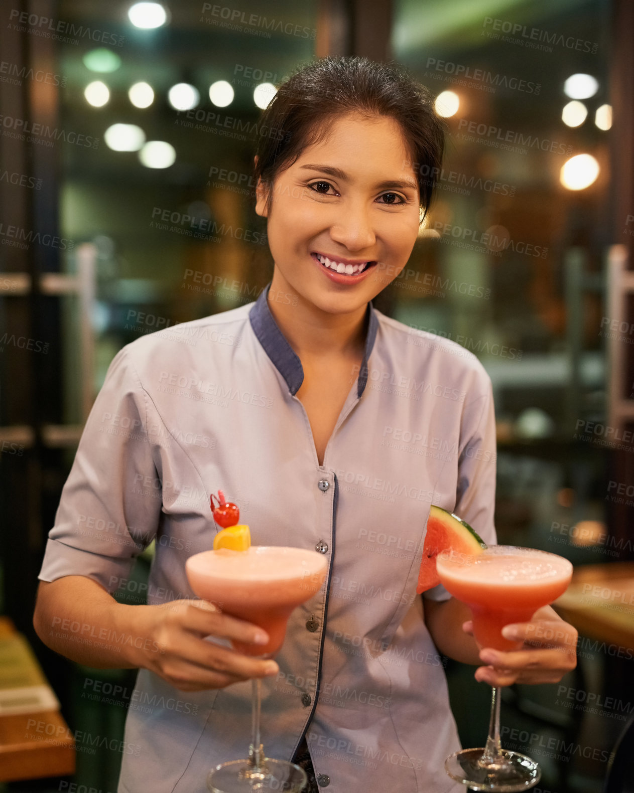 Buy stock photo Portrait of a friendly waitress carrying cocktails in a bar