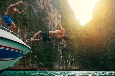 Buy stock photo Shot of a young man doing a backflip off a boat while his friends watch