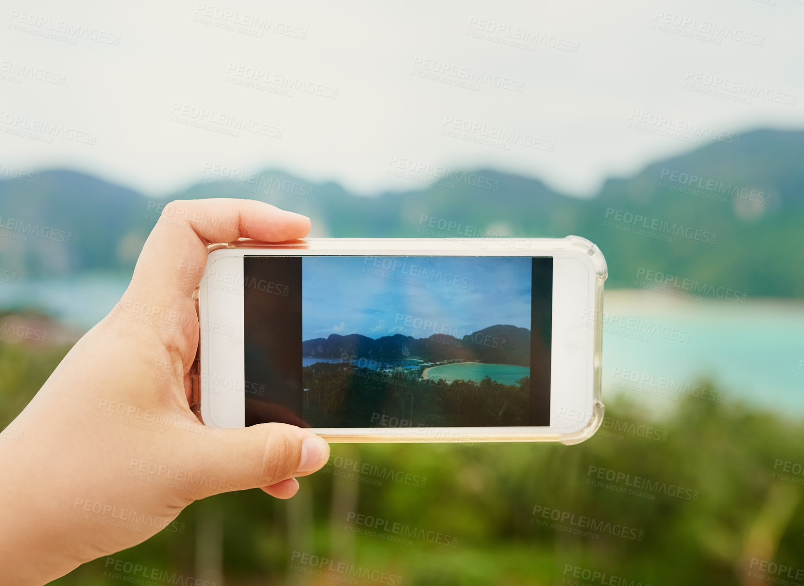 Buy stock photo Cropped shot of an unidentifiable person using a smartphone to photograph a tropical landscape
