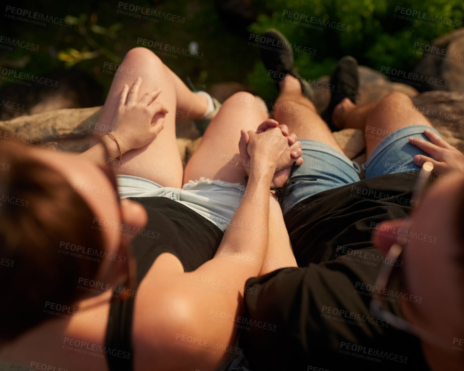 Buy stock photo High angle shot of an unidentifiable couple holding hands while relaxing on vacation