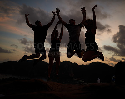 Buy stock photo Shot of a group of jumping friends silhouetted against a sunset
