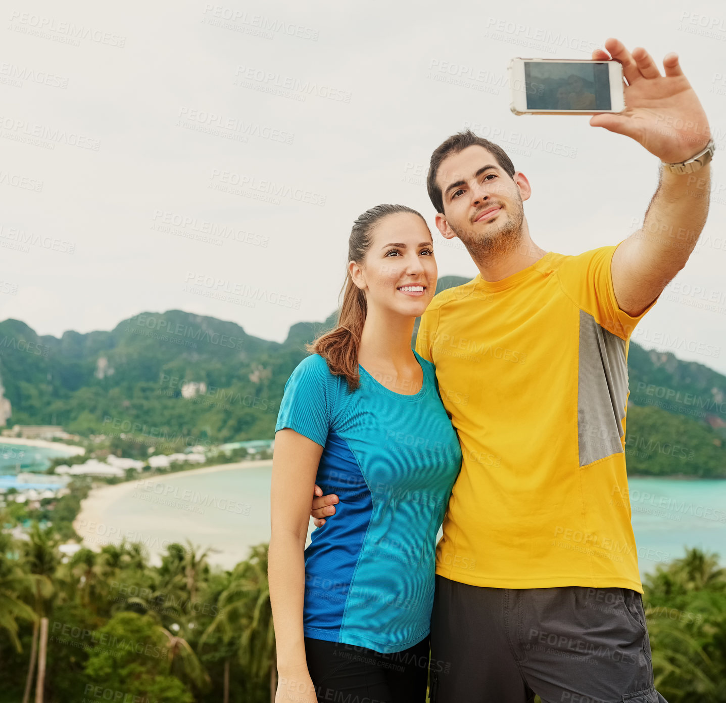 Buy stock photo Shot of a happy young couple taking a selfie on an island vacation